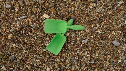 Green children's shovels on the beach.