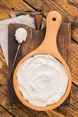 Italian Mascarpone cheese, cream cheese for tiramisu. wooden background. top view