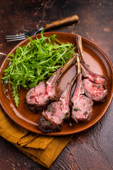 Roasted lamb chop cutlets, mutton meat steaks  with salad. brown background. top view