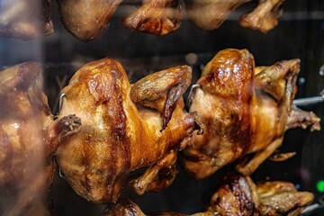 Grilled chickens in spinning rolls at a farmers market in the oven