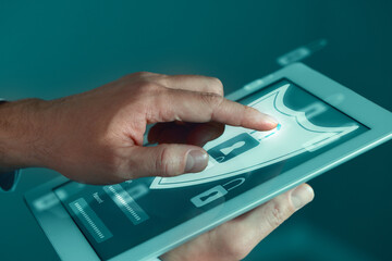 Man unlocking tablet computer, closeup. Password and username boxes, shield and locks on device screen. Cyber security and data protection concept