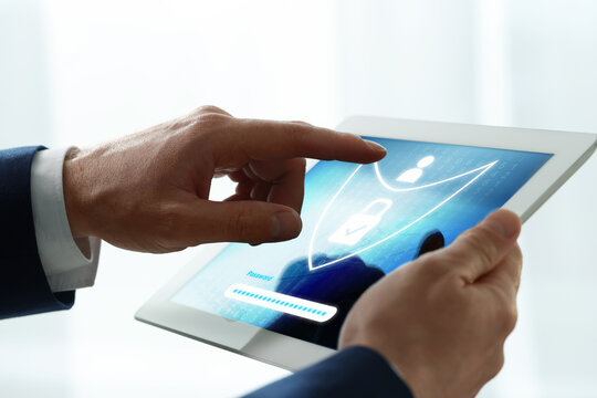 Man unlocking tablet computer, closeup. Password box and shield illustration on device screen. Cyber security and data protection concept - Powered by Adobe