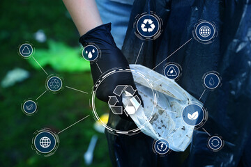 Woman with plastic bag picking up garbage outdoors, closeup. Scheme with recycling symbol and...