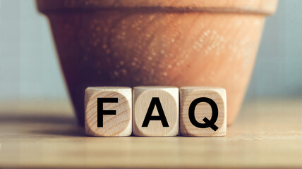 Wooden blocks spelling faq with a terracotta pot in the background ideal for help center customer support or informational website visuals and blog posts about common questions