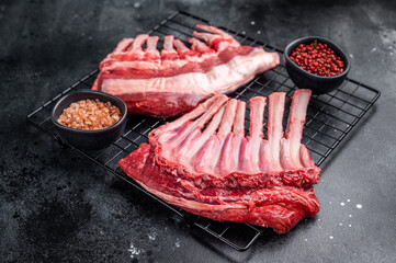 Raw rack of lamb, fresh mutton meat for chops cutlets. black background. top view