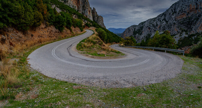 Hairpin mountain road above rocky gorge