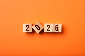 Obraz premium New 2026 year. Cubes with numbers on orange background, top view