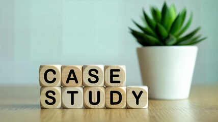 Wooden blocks spelling "case study" on a table with a plant in the background showcase business analysis and learning concepts for educational materials and corporate presentations