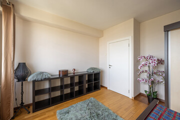 Wooden shelf with artificial flowers in a retro apartment