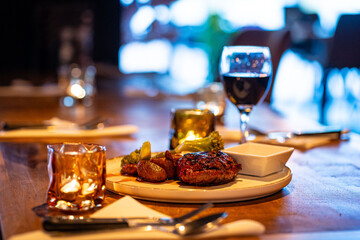 Beef steak meat with vegetables and sauce served with red wine and candles