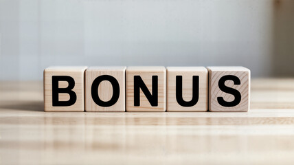 Wooden blocks spelling bonus on a light wood surface ideal for financial incentives employee rewards and promotional campaigns representing extra benefits and positive outcomes