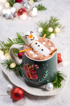 Cozy hot chocolate with a snowman marshmallow on a festive plate during winter celebrations