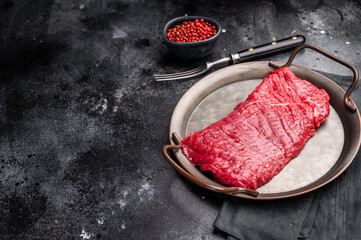 Uncooked flank steak, raw beef flap meat steak. black background. top view