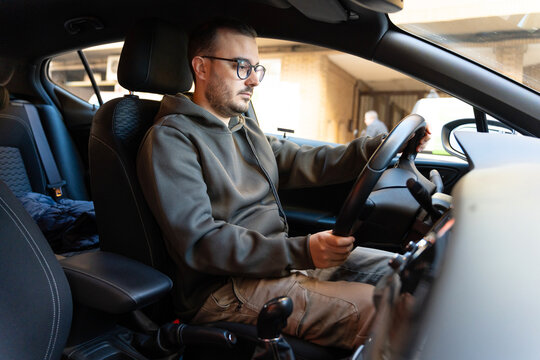 Male freelancer sitting in car driving before work - Powered by Adobe