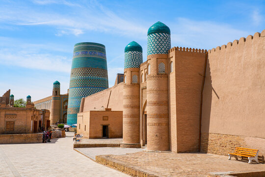Unfinished Kalta Minor minaret and Kuhna Ark in Ichan Kala, the Old City of Khiva, Uzbekistan, Central Asia