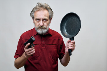 Older man with wrinkles on face skin posing as aggressor in studio