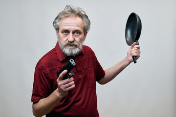 Older man with wrinkles on face skin posing as aggressor in studio