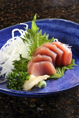 Tuna sashimi with greens on a plate