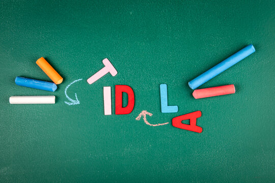 Colorful Wooden Letters Spelling Tidal on Green Chalkboard Background - Powered by Adobe