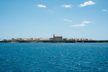 Fototapeta premium Coastal town and fortress overlooking the ocean under a clear blue sky