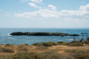 Rocky coastal landscape with blue ocean and clear sky on a sunny day