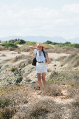 Fototapeta premium Woman in summer outfit hiking in a scenic dry landscape