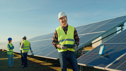 Solar energy workers inspecting solar panels on a sunny afternoon at a green energy site