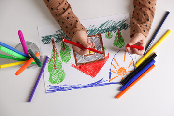 Cute little girl drawing with felt pen at white table, top view
