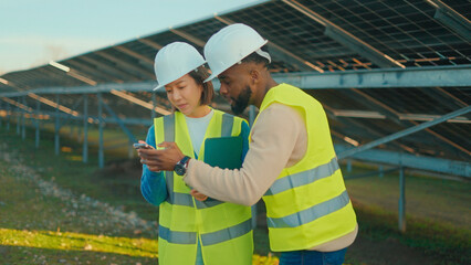 Workers collaborate on solar panel site during daylight, showcasing teamwork in renewable energy projects