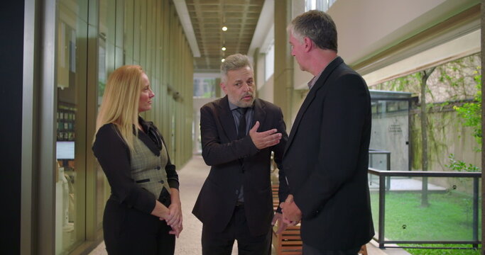 Business manager presenting team members in modern office hallway, colleagues meeting and shaking hands during professional introduction