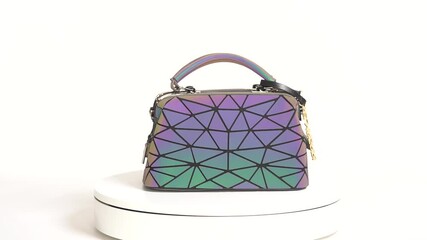 Valmiera, Latvia - November 12, 2020: Colorful geometric handbag displayed on rotating platform, camera zooms in to highlight intricate design details - Powered by Adobe