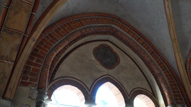 Ornate medieval arches with layered brickwork and painted motifs form the ceiling of Riga Cathedral, showcasing historic craftsmanship and sacred architectural depth.