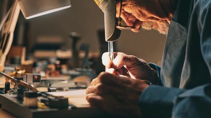 Artist retouching old film negatives on a lightbox using precise tools to restore colors and remove scratches in a retro studio.