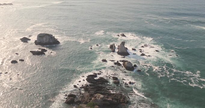 Aerial drone footage of the Cantabrian Sea on the Asturias coast during a colorful sunset. 