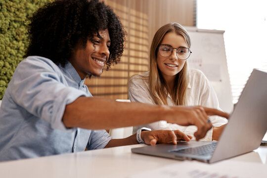 Team brainstorming with laptop in modern office - Powered by Adobe
