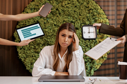 Stressed businesswoman overwhelmed with tasks in modern office