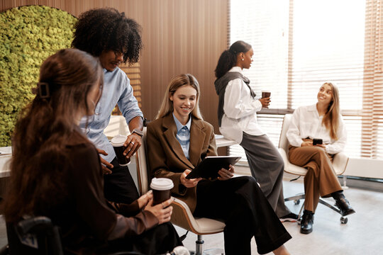 Diverse team having coffee break in modern office