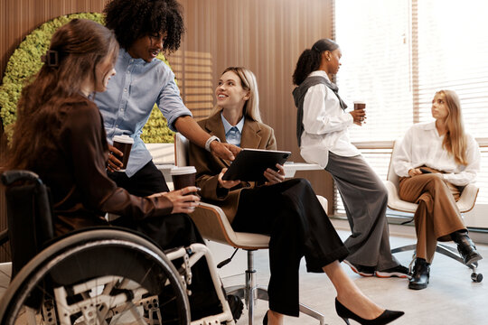 Diverse team having coffee break in modern office