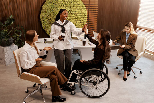 Team diversity and inclusion concept, women celebrating success at modern office