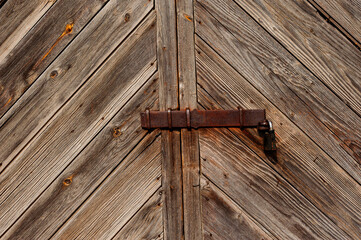 Old wooden doors and rusty padlock in the barn.