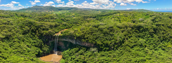 Chamarel, Mauritius rainforest valley with double cascade waterfall emerald foliage rugged canyon walls and distant volcanic ridges