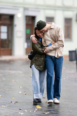 Happy young couple hugging walking outdoors