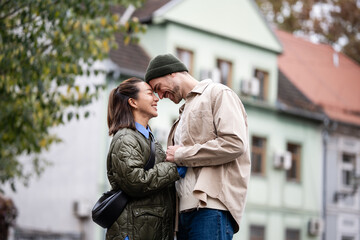 Interracial couple smiling expressing love and intimacy in city