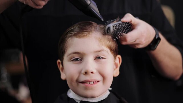 Young caucasian boy at hair salon getting haircut by barber in retro barbershop. - Powered by Adobe