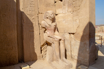 Egypt, Luxor, 01.02.2022.Massive ancient Egyptian stone statue of a pharaoh standing in Karnak temple ruins with carved details