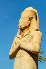 Egypt, Luxor, 01.02.2022.Massive ancient Egyptian stone statue of a pharaoh standing in Karnak temple ruins with carved details