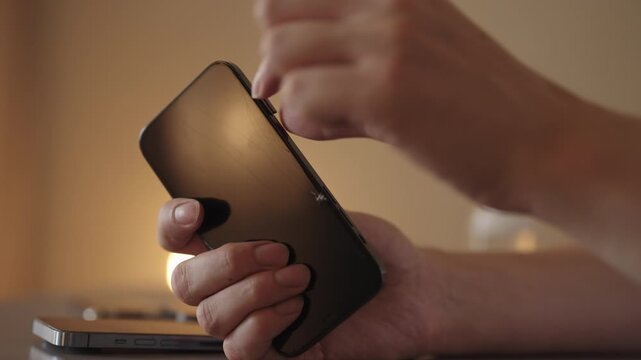 Close-up of male hands manipulating sim card for insertion into modern smartphone, representing phone setup, mobile communication, new technology integration. Shooting in slow motion.