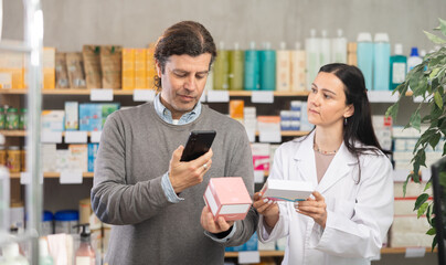 Man scans the packages with pills on mobile barcode, he reads detailed instructions on the pharmacy's website and looks at similar products. Purchase and payment for goods using a QR code