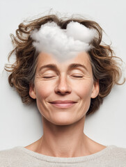 Minimalist portrait of a mature woman with her eyes gently closed and a serene smile, lying down against a bright white background.