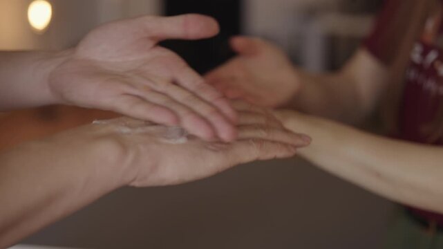Couple hands applying moisturizer, enjoying relaxing moment of self-care and mutual affection, promoting healthy skin and wellness together, close-up. Shooting in slow motion.